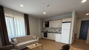 A modern apartment with a living area, kitchenette, and a dining space. - Mimoza Apart (TRABZON)