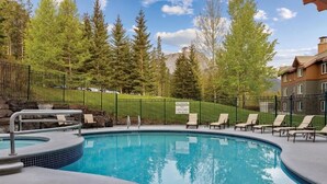 A swimming pool with lounge chairs, a stone wall, and a sign indicating no diving. - Serene location, spaceous with pool and easy access to Banff and Lake Louise (Canmore)