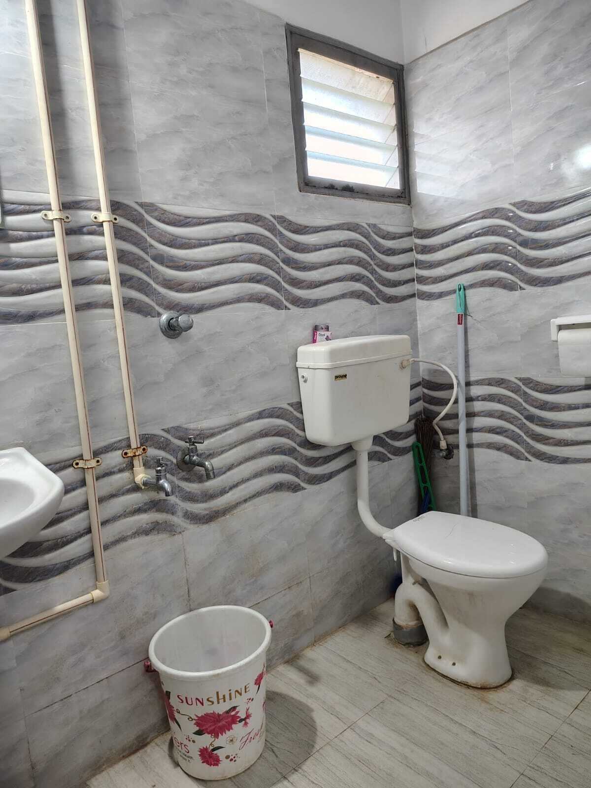 A bathroom with a toilet, sink, and shower area.