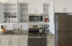 A modern kitchen with stainless steel appliances, including a microwave, oven, and refrigerator.