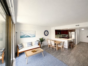 Ein modernes Wohnzimmer mit Sofa, Couchtisch und Essbereich.