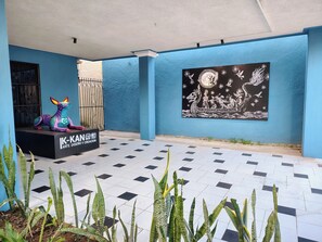 Ein blauwandiges Gebäude mit Fliesenboden, einer Skulptur und einem Wandbild.