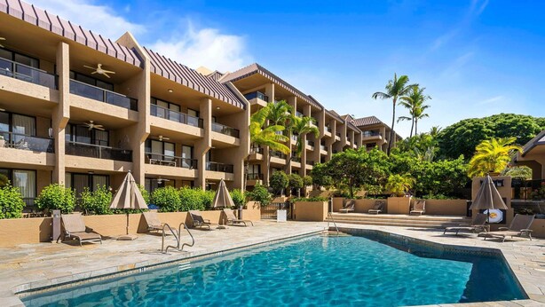 A hotel with a swimming pool, multiple balconies, and palm trees. - Walk to Historic Kailua Village Kona Pacific C317 w/ A/C & Large Lanai (Kailua-Kona)