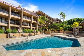 A hotel with a swimming pool, multiple balconies, and palm trees. - Walk to Historic Kailua Village Kona Pacific C317 w/ A/C & Large Lanai (Kailua-Kona)