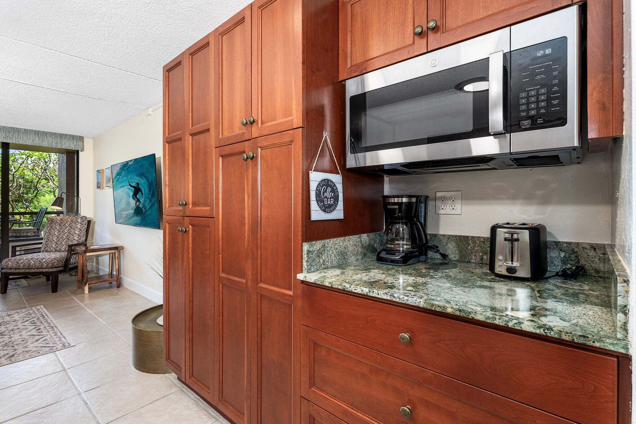 A kitchen with wooden cabinets, a microwave, a toaster, and a coffee maker.