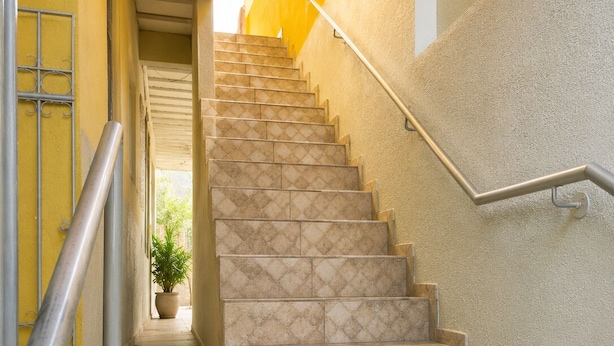 A staircase with a handrail, leading to an upper floor.