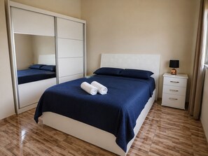 Une chambre à coucher avec un lit, une table de chevet, une lampe et une armoire.