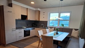 Een moderne keuken met een eethoek, een bank en een raam met uitzicht.
