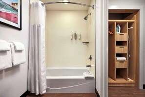 Ein Badezimmer mit Badewanne, Dusche und einem Holzschrank.