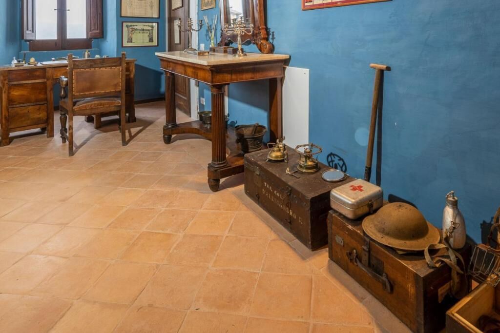 Ein Zimmer mit einem Holztisch, einem Stuhl und einer blauen Wand mit gerahmten Bildern.