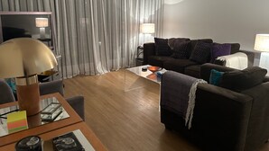 A living room with a sofa, a coffee table, a lamp, and a TV. - Sleeps4-familyfriendly-kingbeds-2bath (London)