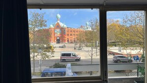 Vista di un edificio con una cupola e una facciata rossa, vista da una finestra.