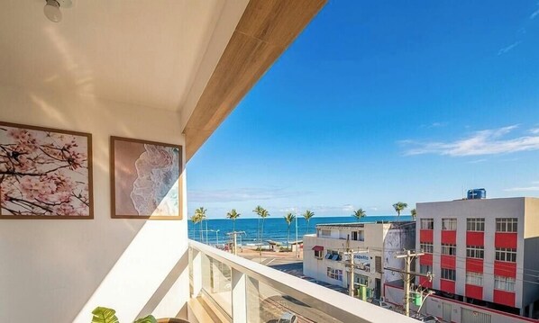 Ein Balkon mit Blick auf das Meer und Gebäude.