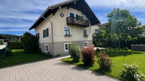 A two-story building with a balcony, a paved driveway, and a well-maintained lawn.