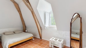 Une chambre à coucher avec un lit, un miroir et une fenêtre.