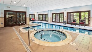 Une piscine avec un jacuzzi, des chaises longues et une vue sur l’extérieur.