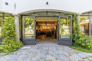 Una casa moderna con un vialetto in pietra che conduce a un ingresso con porta in vetro.