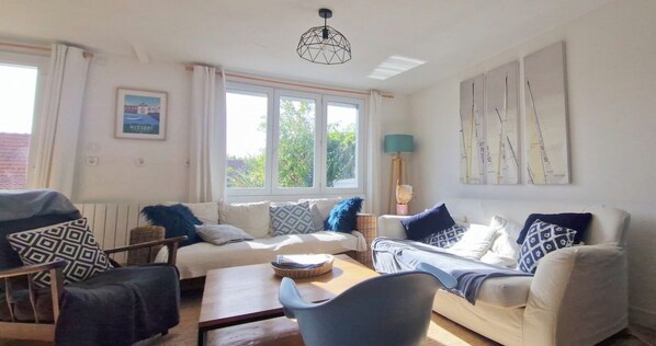 A living room with a sofa, armchair, and a table with a lamp. - Bright family home near the beach (Wissant)