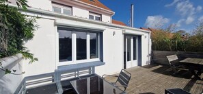 A house with a patio, a wooden deck, and a window overlooking the garden. - Bright family home near the beach (Wissant)