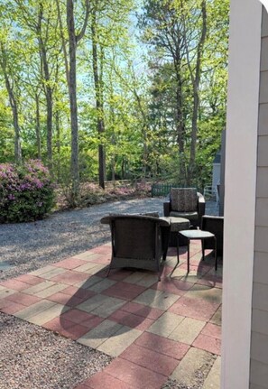 A patio with outdoor furniture and a gravel path.