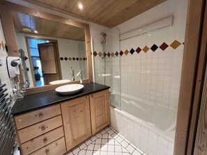 A bathroom with a wooden vanity, a sink, a mirror, and a shower. - 20 meters from the ski slopes, 1st floor, sauna, patio, balcony, TV, 64 m², Peisey-Vallandry (Peisey-Nancroix)