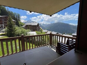 Ein Balkon mit Blick auf Berge und Bäume.