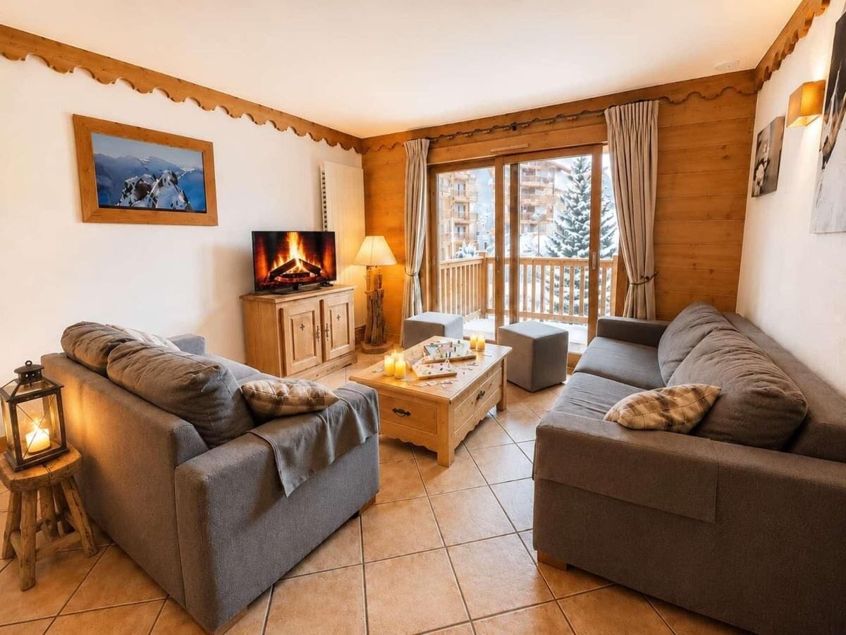 Un salon chaleureux avec une cheminée, des canapés, une table basse et un téléviseur.