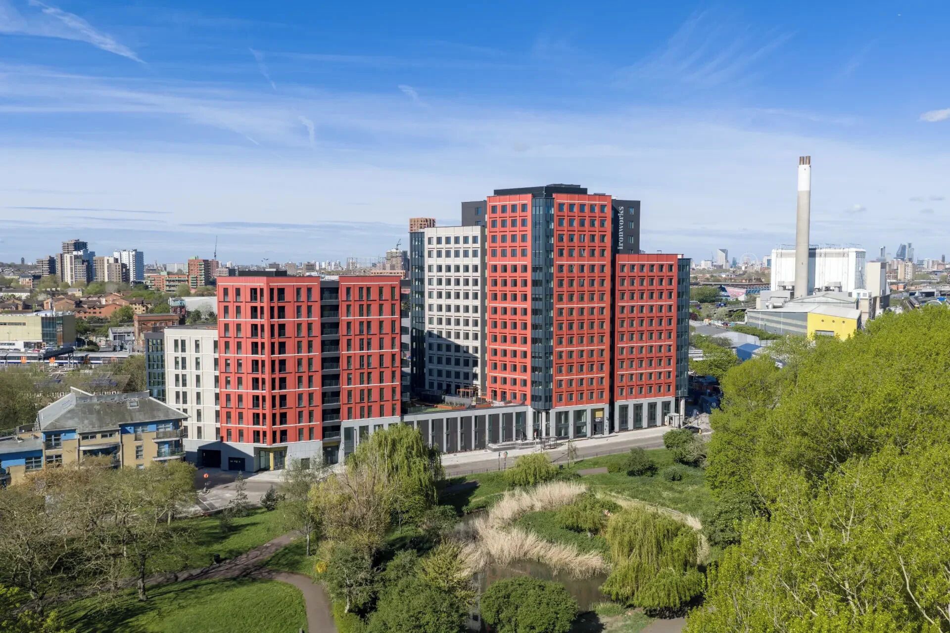 A multi-story building with a modern architectural design, surrounded by greenery and other urban structures.