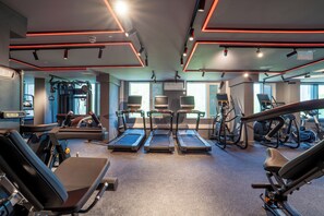 Ein Fitnessstudio mit Laufbändern, Kraftgeräten und Trainingsausrüstung.