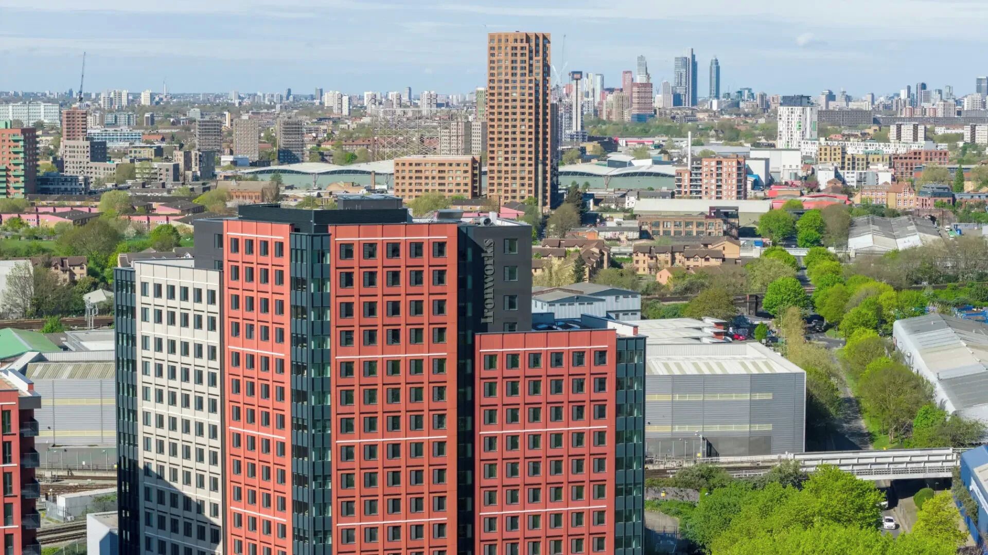Un paisaje urbano con edificios modernos y altos, incluyendo una estructura prominente roja y blanca.