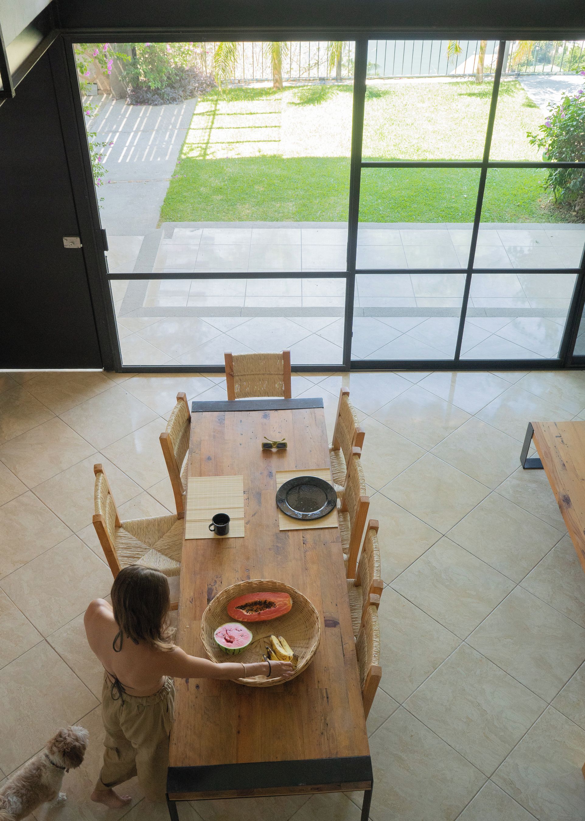 Un espacio habitable de concepto abierto con una mesa de comedor, sillas y vistas a un área exterior a través de puertas de vidrio grandes.