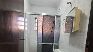 Ein Badezimmer mit Toilette, Waschbecken und einer Duschkabine aus Glas.
