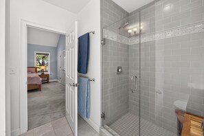 A modern bathroom with a glass-enclosed shower, a visible toilet, and a towel rack. - Contemporary 3BR House: New Furniture, AC, Hot Tub, 2Gbps Wi-Fi & Pet-Friendly (Falmouth)