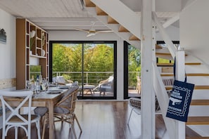 Ein modernes Interieur mit Essbereich, Treppe und Blick ins Freie.