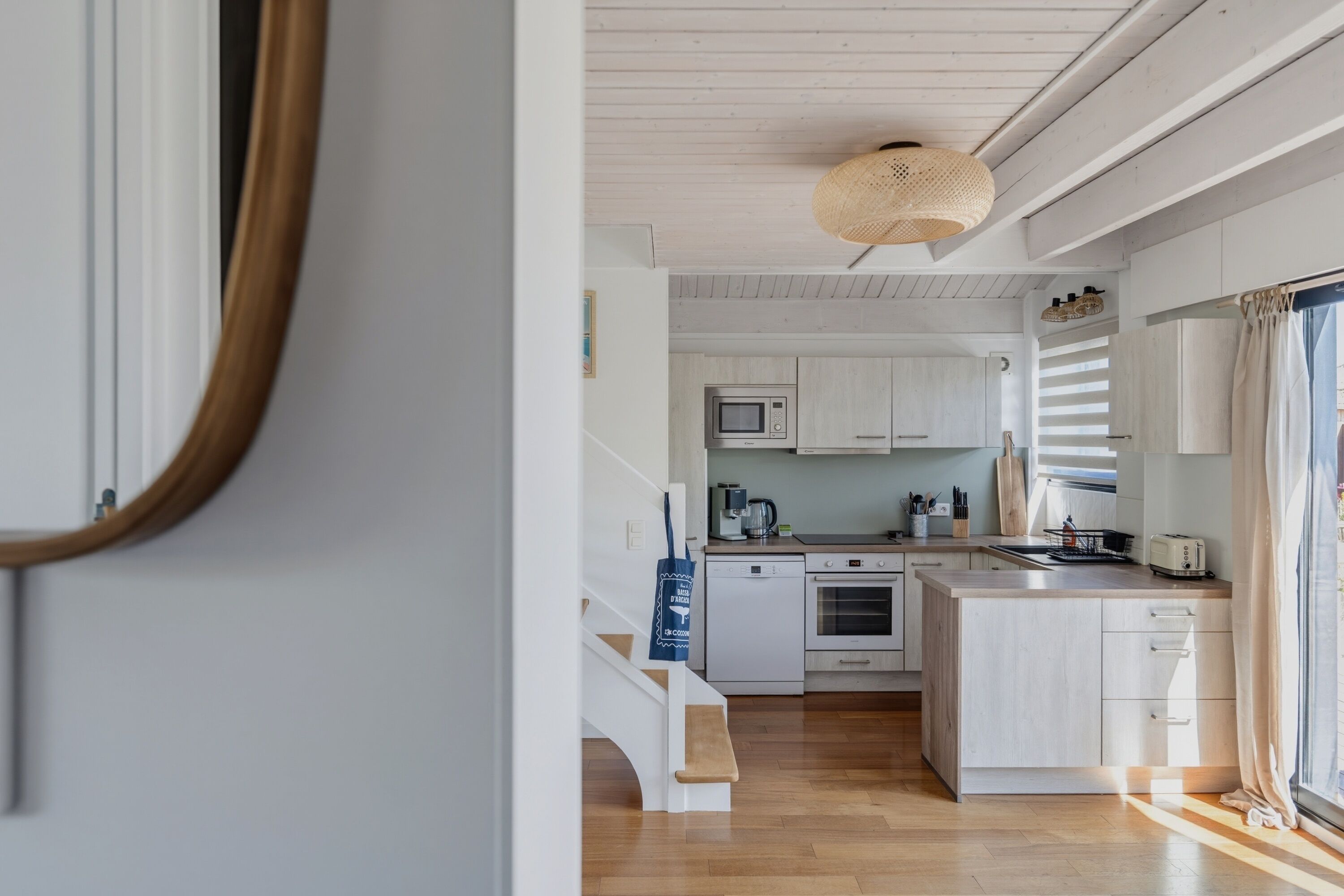 A modern kitchen with white cabinetry, a microwave, a stove, and a sink.