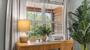 Ein Holztisch mit einer Lampe, einem Drucker und einer Topfpflanze.