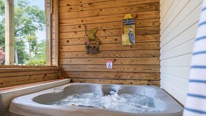 Ein Whirlpool in einer Holzhütte mit Holzwand und Fenster.
