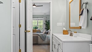A bedroom with a bed, bedside table, and a window with curtains.