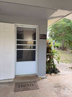 Uma porta da frente com uma placa que diz 'O que acontece no pátio, fica no pátio'.