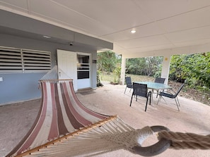 A covered outdoor area with a hammock, a table with chairs, and a door labeled 'Patio.'