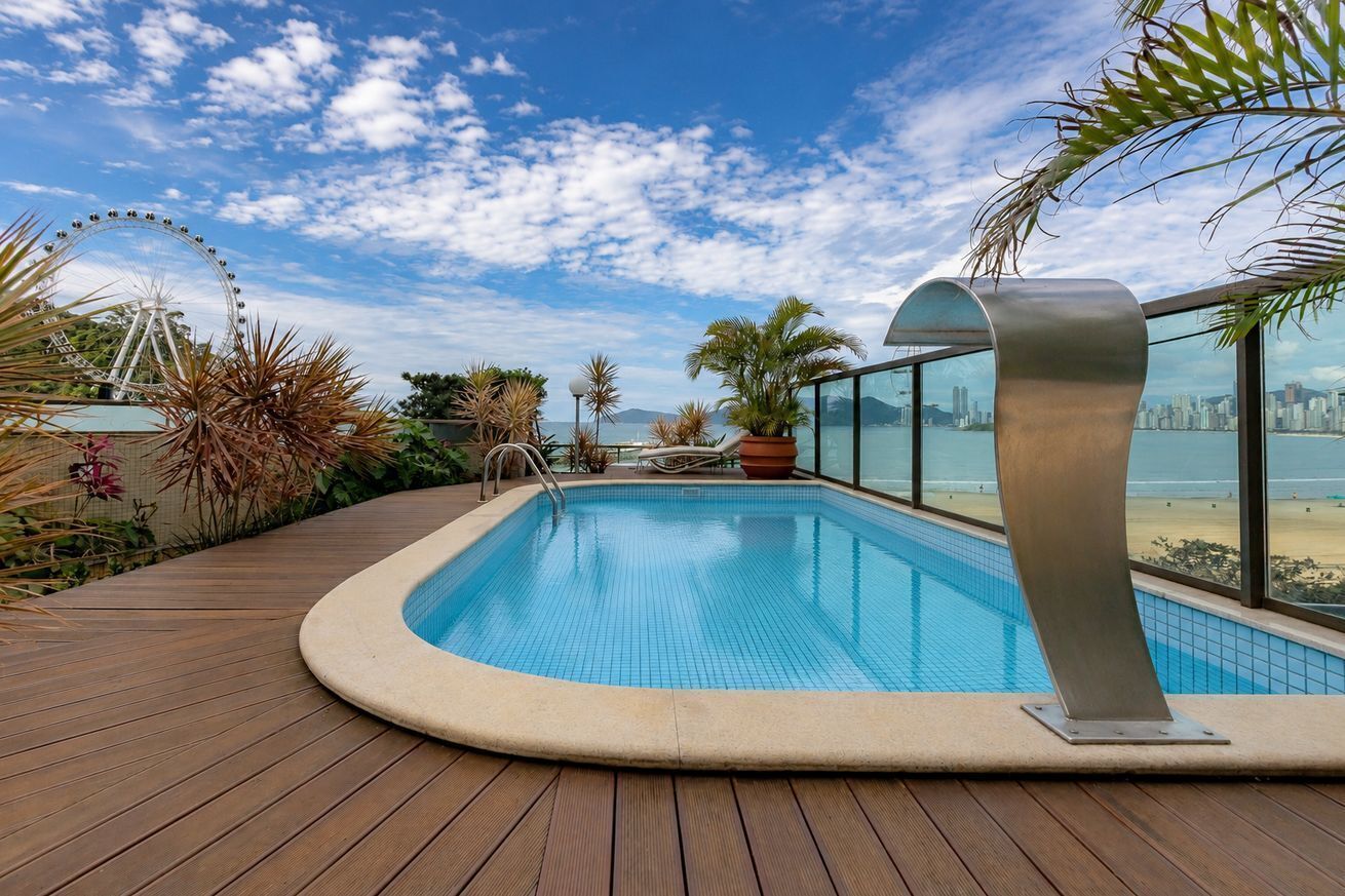 A swimming pool with a view of a city skyline and a Ferris wheel.