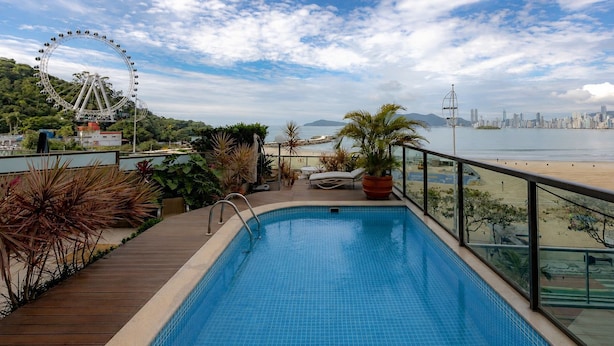Une piscine offrant une vue sur les gratte-ciel d’une ville et sur une grande roue.