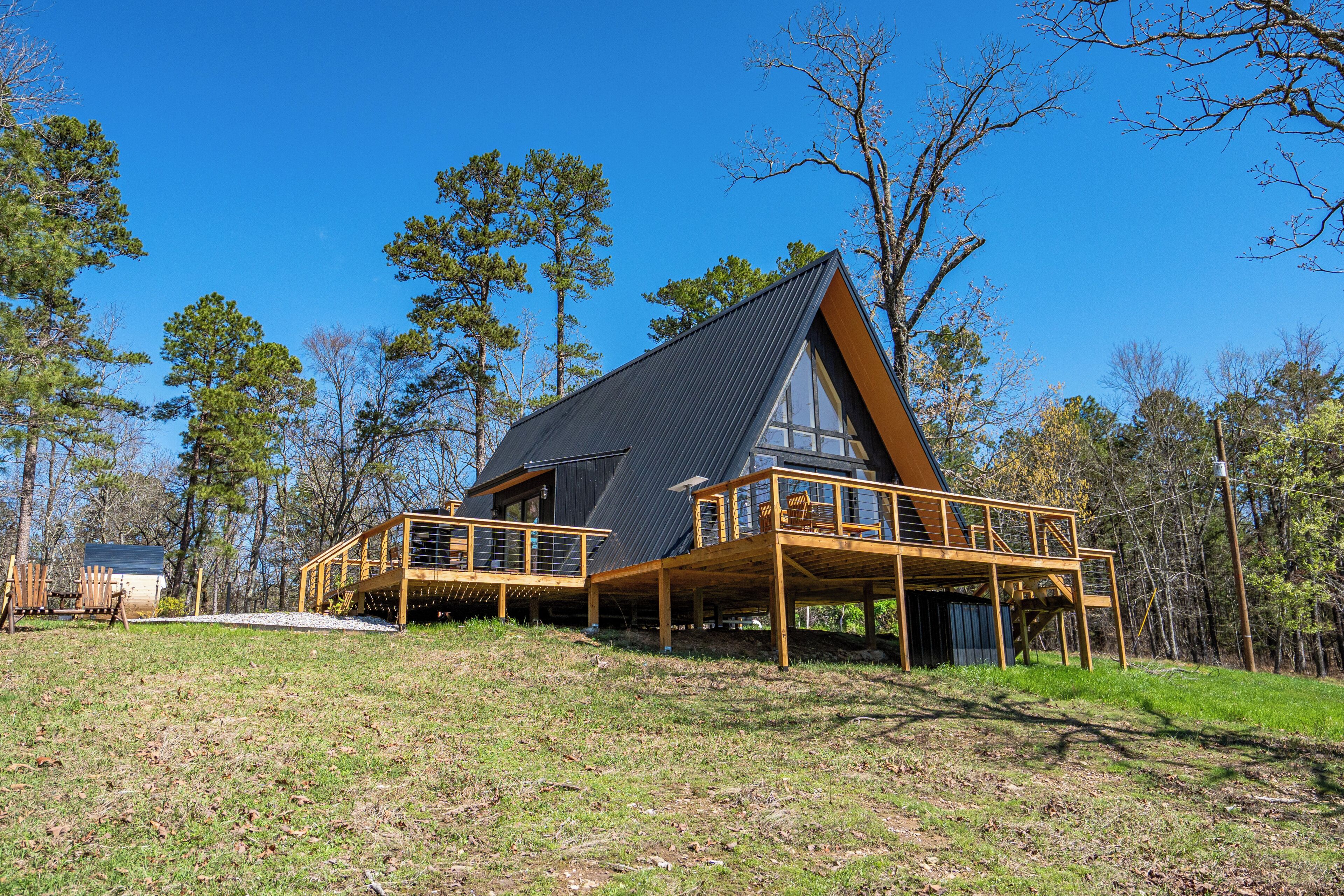 A modern house with a steep roof, wooden deck, and large windows.