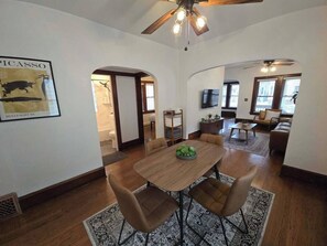 A dining area with a wooden table and chairs, a ceiling fan, and a framed artwork on the wall. - Whole Contemporary House in Bay View (Milwaukee)