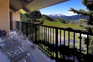 A balcony with a view of a mountain, outdoor seating, and a railing. - Columbine 2308 (Crested Butte)