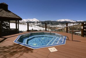 A hot tub on a wooden deck with a view of snow-covered mountains. - Columbine 2308 (Crested Butte)