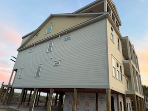 A two-story building with a gabled roof and multiple windows. - Brand New Oceanfront, 10BR, Pool/Spa, & Elevator (Georgetown County)