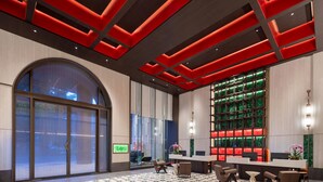 Een moderne lobby met een groot boogvenster, een receptiebalie en een vloer met een patroon.