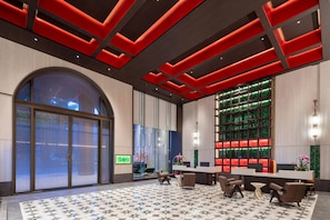 Eine moderne Lobby mit einem großen Bogenfenster, einem Empfangstresen und einem gemusterten Boden.