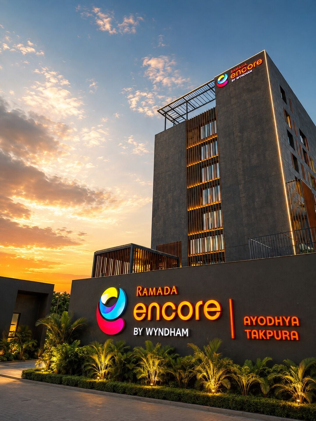 En moderne bygning med et skilt, der viser 'Ramada Encore by Wyndham' og 'Ayodhya Takpura', der angiver et hotel.